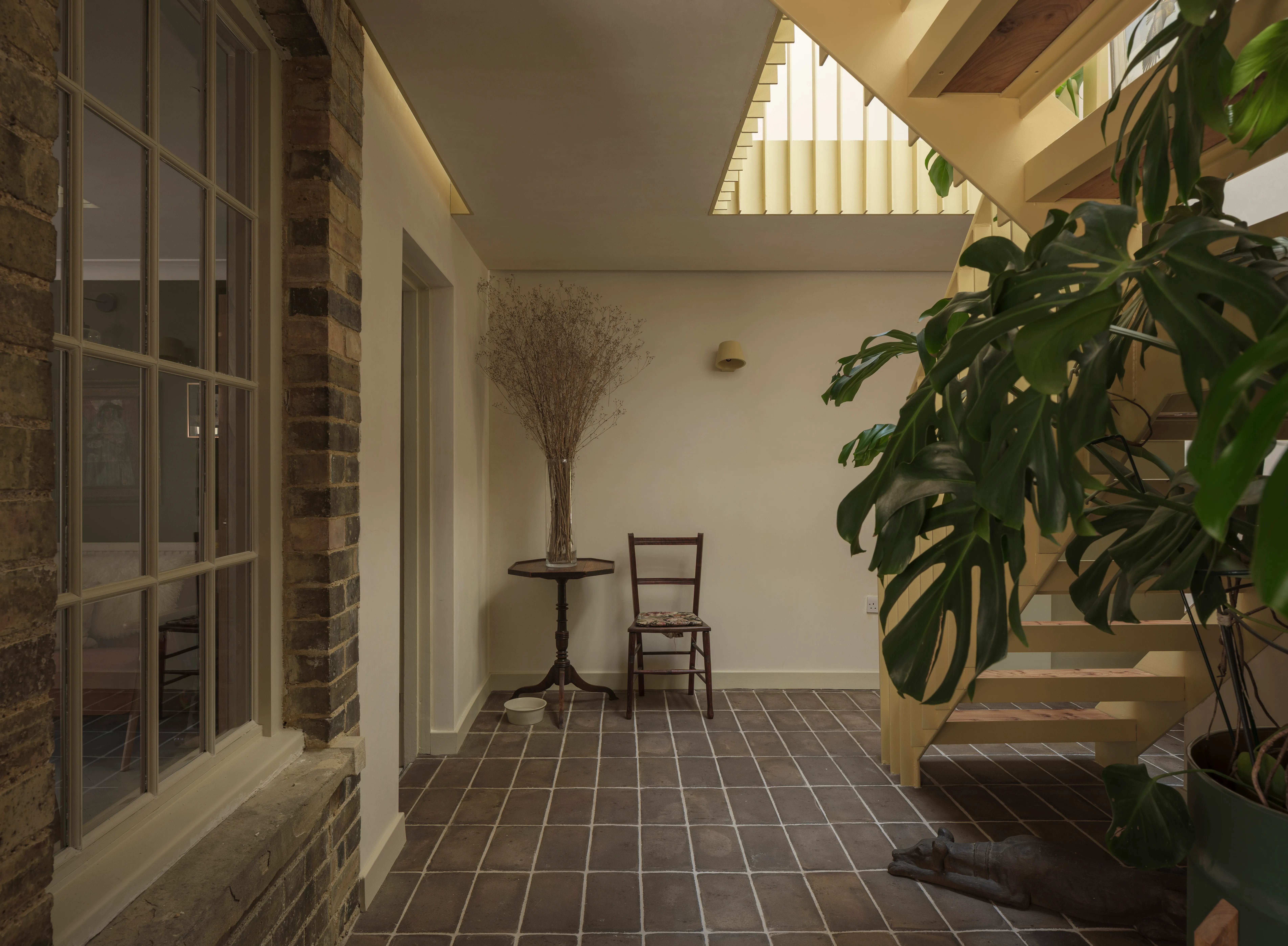 Interior of East Croft, showing a steel staircase, exposed brick and a rooflight above the hallway